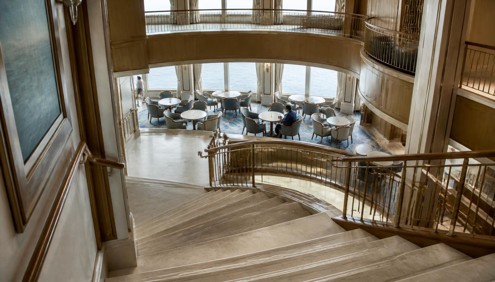 An open stairwell and daytime seating area inside a ship